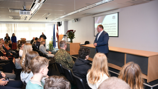 ministrs saka uzrunu zāles priekšā