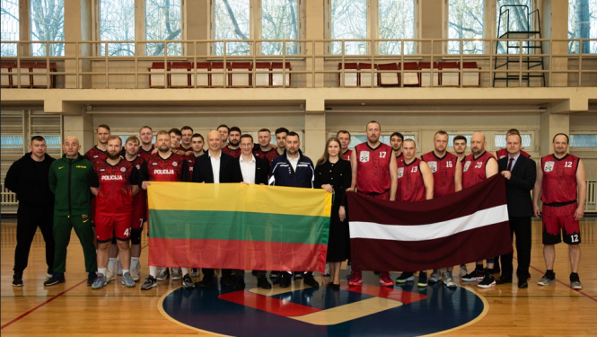 Komandas stāv ar Lietuvas un Latvijas karogu zālē