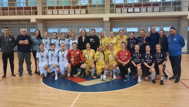 Cilvēki krāsainos formas tērpos ar medaļām sporta zālē