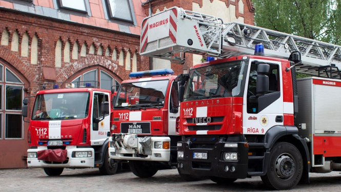 Ugunsdzēsēju mašīnas pie ēkas