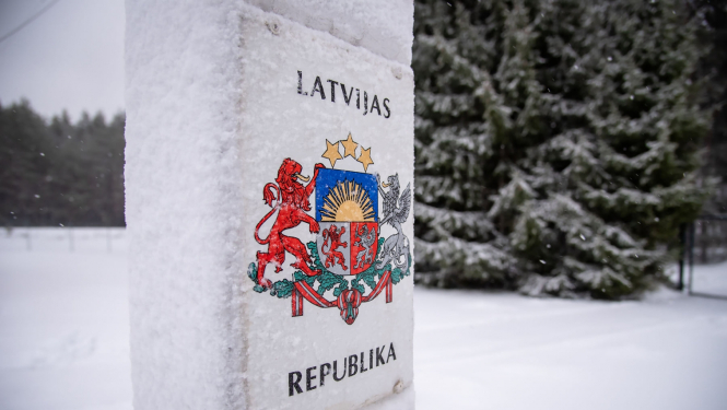 Robežstabs ziemā, fonā mežs