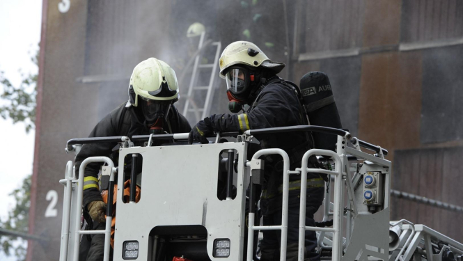 divi ugunsdzēsēji uz paceļamām kāpnēm