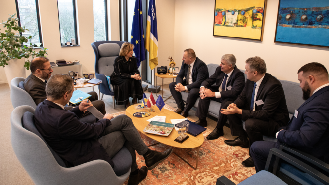 personas sēž ap galdu