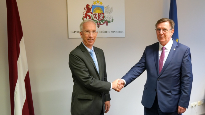 Iekšlietu ministrs un ASV vēstnieks Latvijā sarokojas