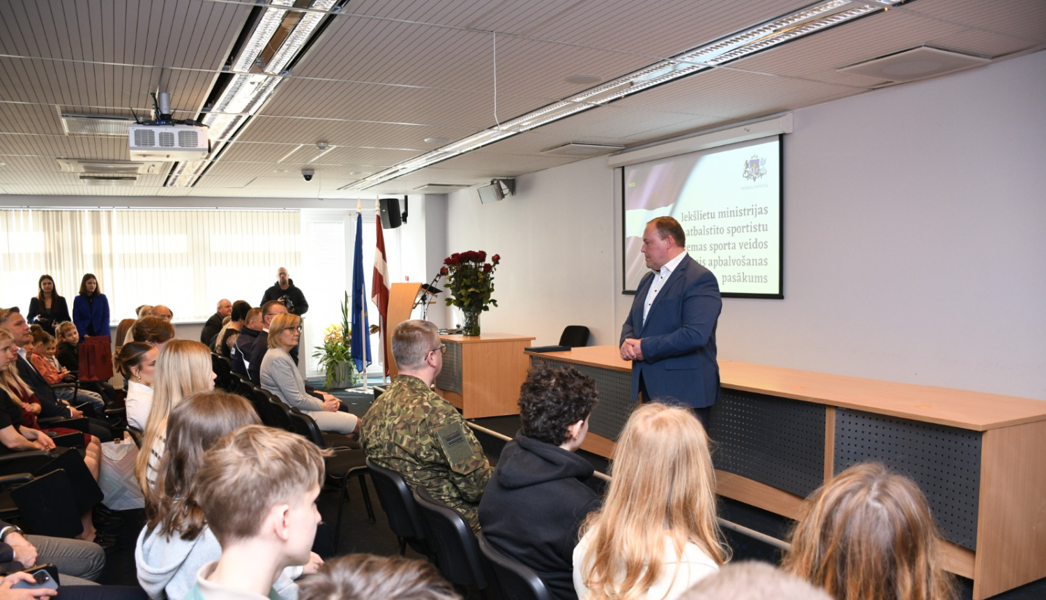 ministrs saka uzrunu zāles priekšā