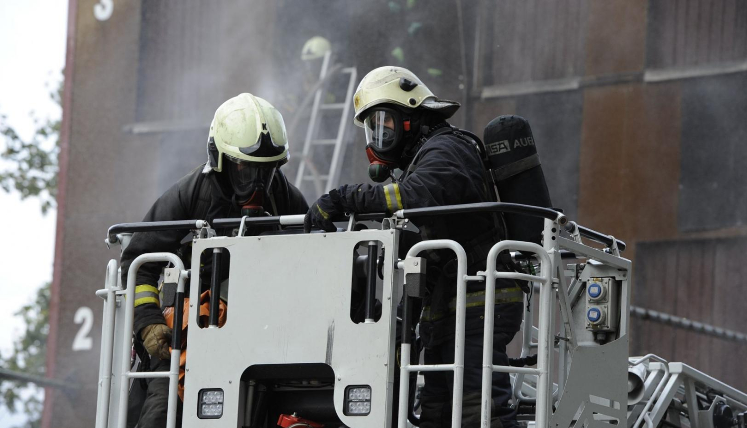 divi ugunsdzēsēji uz paceļamām kāpnēm