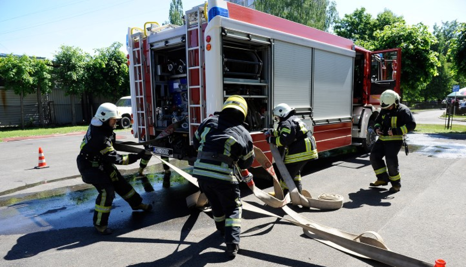 Ugunsdzēsēji pie ugunsdzēsēju automašīnas