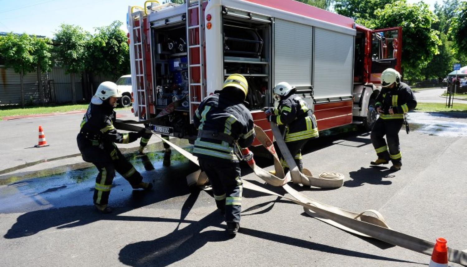 Ugunsdzēsēji pie ugunsdzēsēju automašīnas