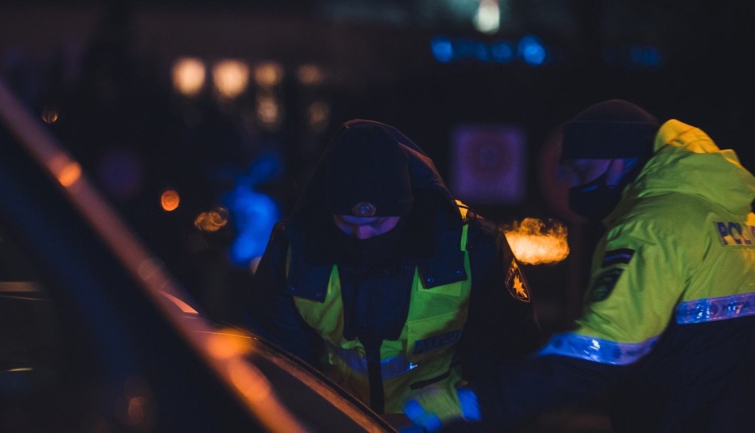 robežsargs un policists noliekušies pie mašīnas